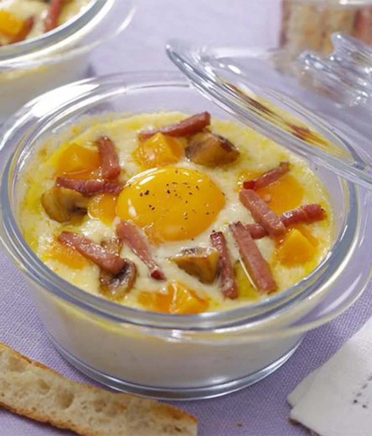 Œufs cocotte cuits au four, prêts à être dégustés avec des herbes fraîches