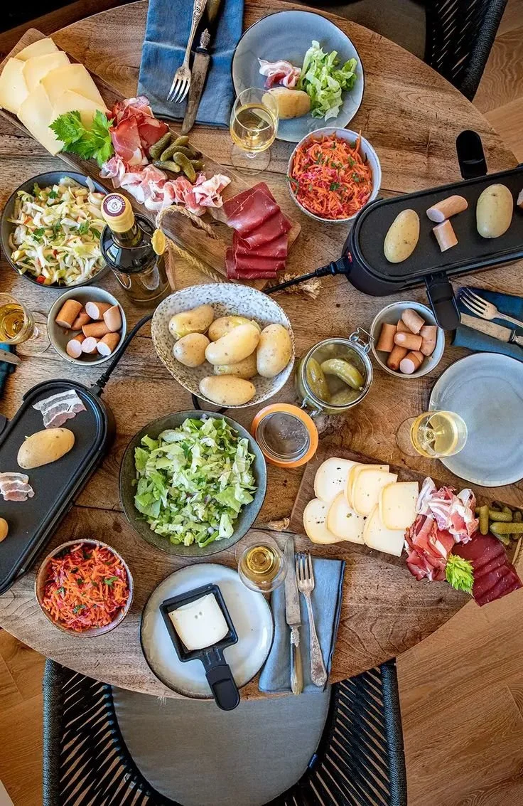 Raclette savoureuse prête à être servie, accompagnée de légumes et de pains.
