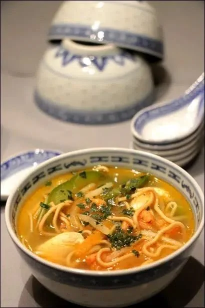 Soupe chinoise gourmande aux crevettes servie dans un bol avec légumes frais