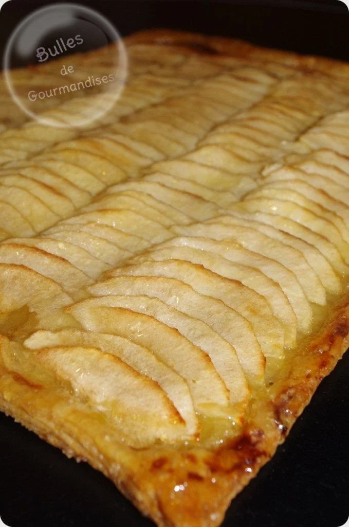 Tarte fine aux pommes servie avec une boule de glace à la vanille.